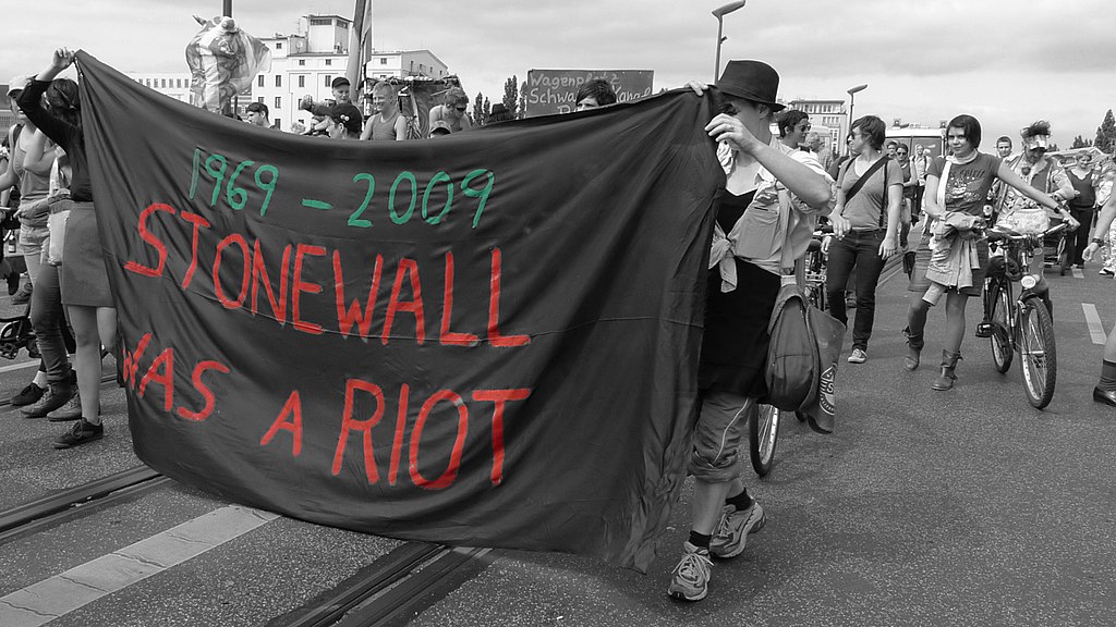 LGBTQ+ Pride parade banner being carried in protest against the commercialisation of Pride parades, reading "1969-2009 Stonewall was a riot"